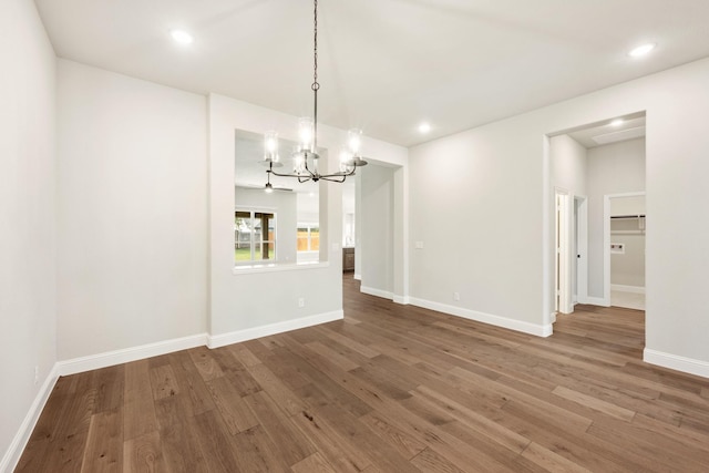 unfurnished dining area featuring wood-type flooring and an inviting chandelier