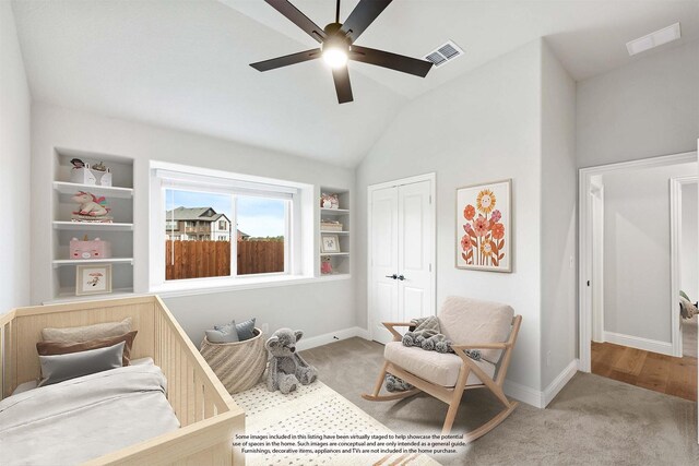 sitting room featuring light carpet, built in shelves, vaulted ceiling, and ceiling fan