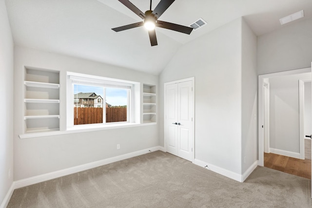 unfurnished bedroom with light carpet, a closet, ceiling fan, and lofted ceiling