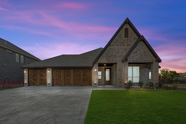 view of front of home with a garage and a lawn