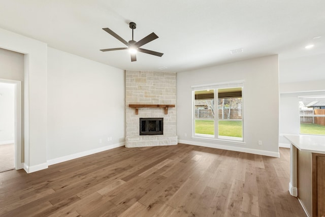 unfurnished living room featuring a fireplace, hardwood / wood-style floors, and ceiling fan