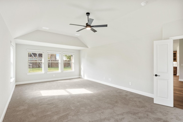 carpeted empty room featuring ceiling fan and vaulted ceiling