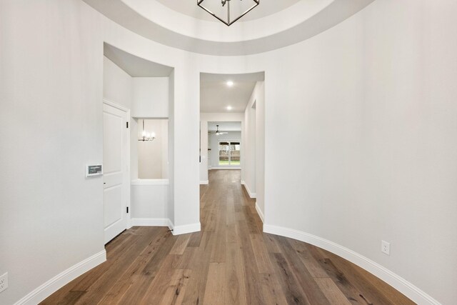 hallway featuring hardwood / wood-style floors and a chandelier