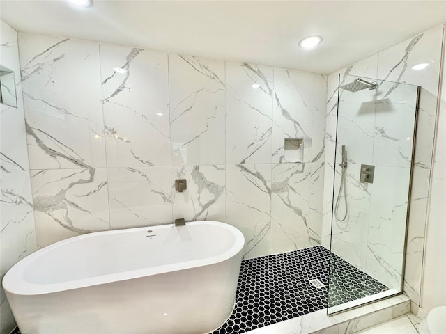 bathroom with tile walls and independent shower and bath