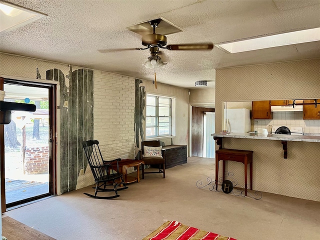 interior space featuring decorative backsplash, a breakfast bar area, kitchen peninsula, white appliances, and ceiling fan