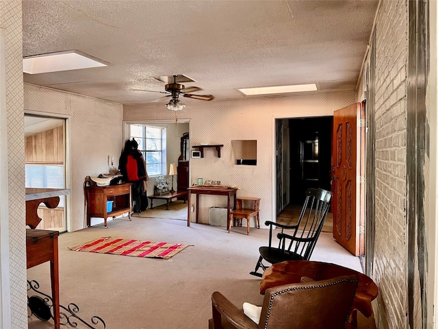 sitting room with ceiling fan, light carpet, and a textured ceiling