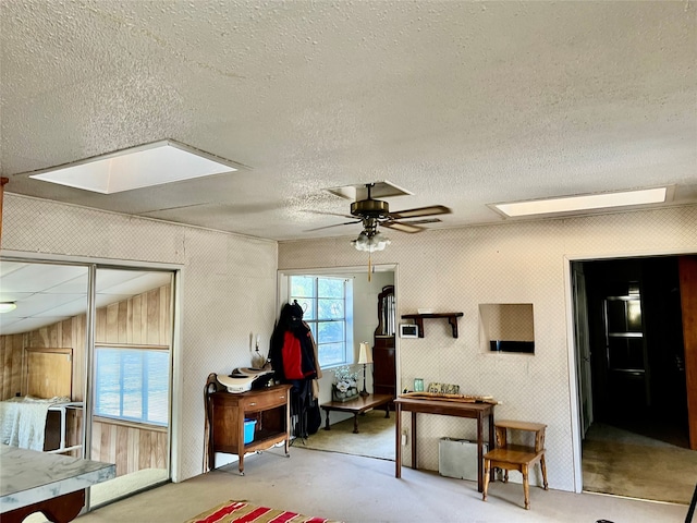 misc room with lofted ceiling, wooden walls, concrete floors, a textured ceiling, and ceiling fan