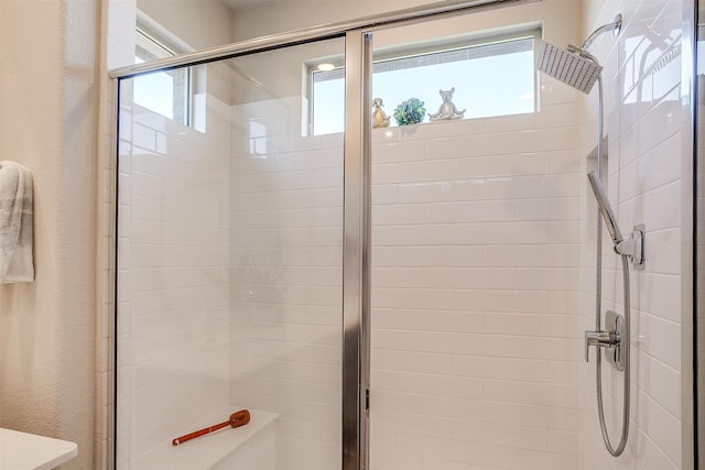 bathroom with a wealth of natural light and a shower with shower door