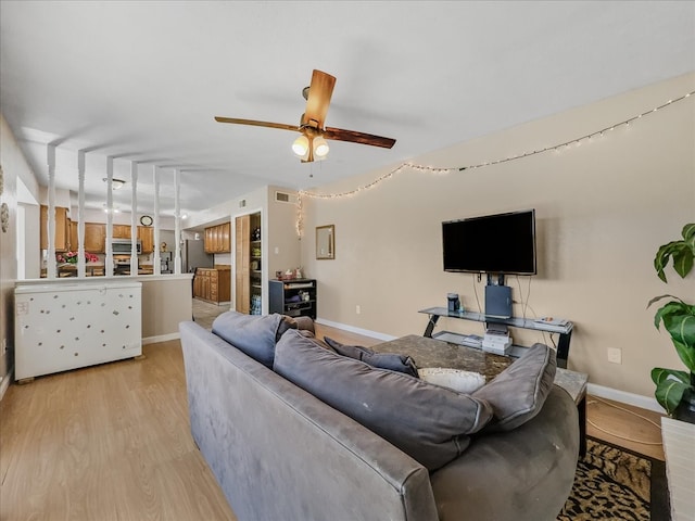 living room featuring ceiling fan and light wood-type flooring