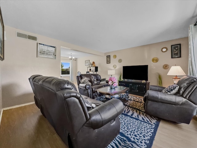 living room with hardwood / wood-style floors and a notable chandelier