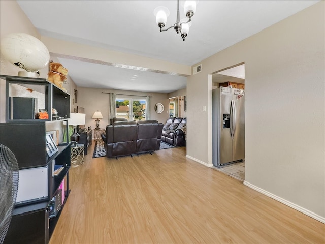 living room with a notable chandelier and light hardwood / wood-style flooring