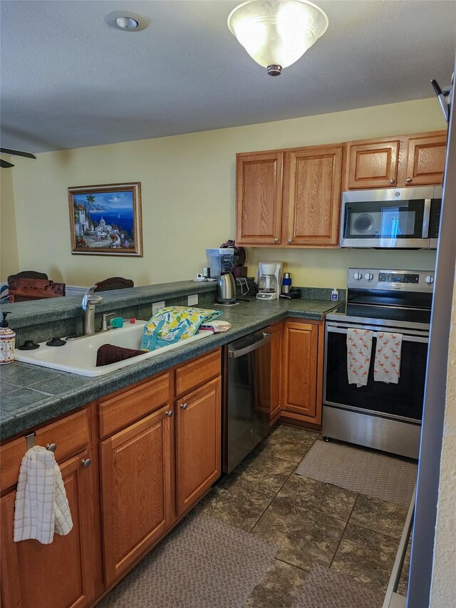 kitchen with tile countertops and appliances with stainless steel finishes