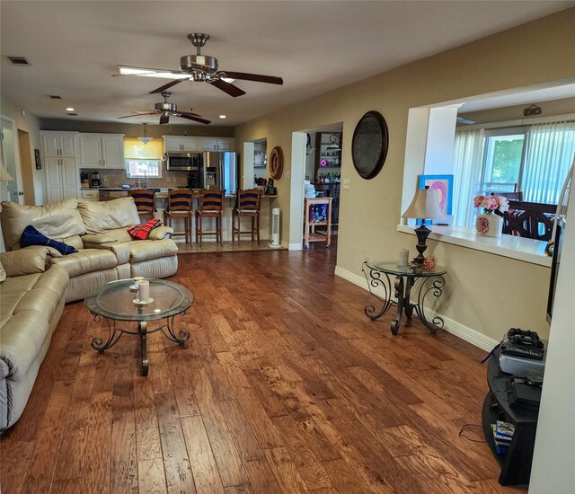 interior space with a wealth of natural light, ceiling fan, and dark hardwood / wood-style flooring