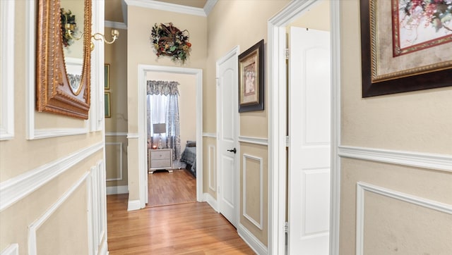 corridor with crown molding and light hardwood / wood-style flooring