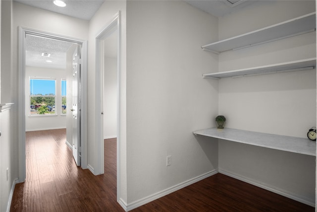 corridor with visible vents, baseboards, a textured ceiling, and dark wood-style floors