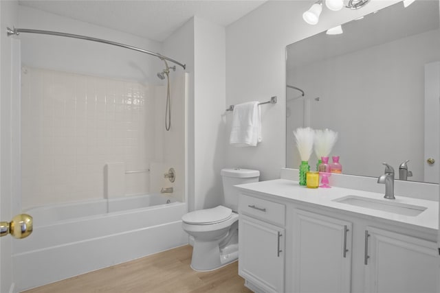 bathroom with washtub / shower combination, toilet, wood finished floors, and vanity