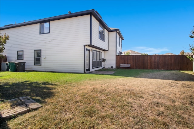 back of house with a lawn