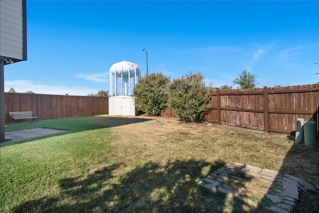 view of yard with a storage shed, an outdoor structure, and a fenced backyard