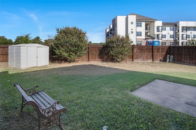 view of yard with an outbuilding, a fenced backyard, a storage shed, and a patio area