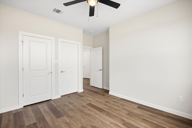 unfurnished bedroom with ceiling fan and dark hardwood / wood-style flooring