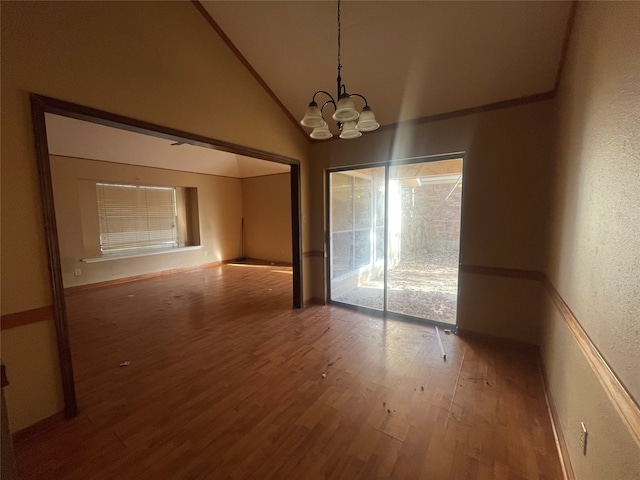 unfurnished dining area with hardwood / wood-style floors, high vaulted ceiling, and a chandelier