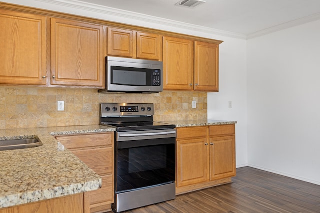 kitchen featuring dark hardwood / wood-style flooring, backsplash, light stone counters, stainless steel appliances, and crown molding