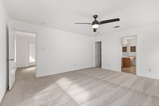 unfurnished bedroom with connected bathroom, ceiling fan, and light colored carpet