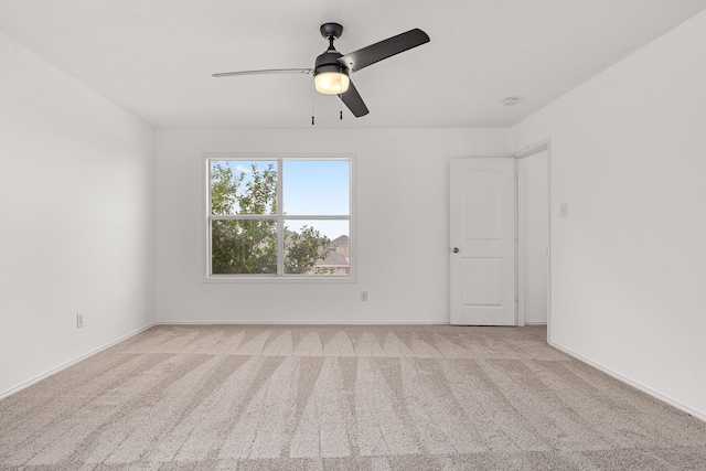 empty room with ceiling fan and light carpet