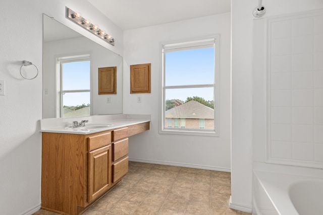 bathroom with vanity, plenty of natural light, and a tub