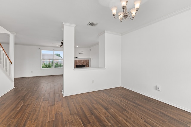 unfurnished living room featuring ceiling fan with notable chandelier, dark hardwood / wood-style flooring, ornamental molding, and a brick fireplace