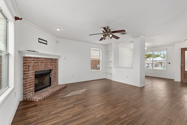 unfurnished living room with ornamental molding, dark wood-type flooring, and a brick fireplace