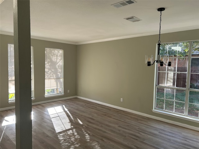 empty room with ornamental molding and hardwood / wood-style flooring