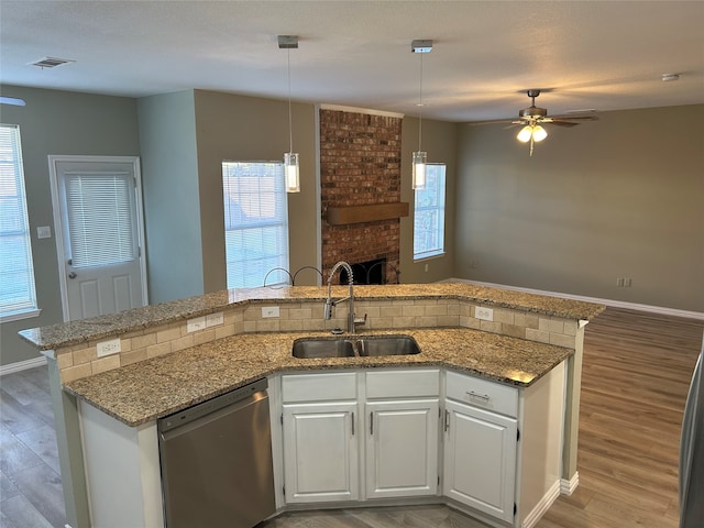 kitchen featuring white cabinets, stainless steel dishwasher, sink, and wood-type flooring