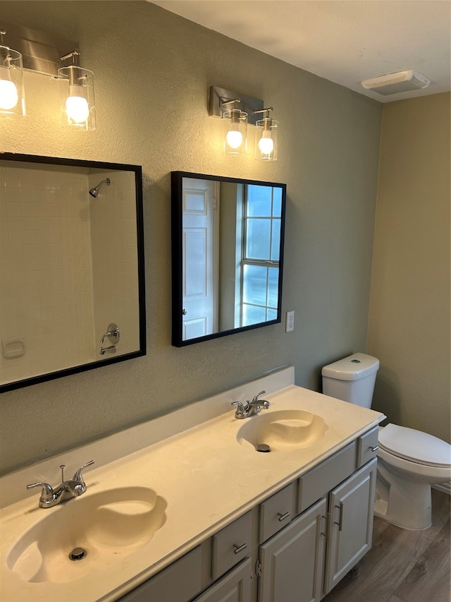 bathroom featuring vanity, toilet, hardwood / wood-style flooring, and walk in shower