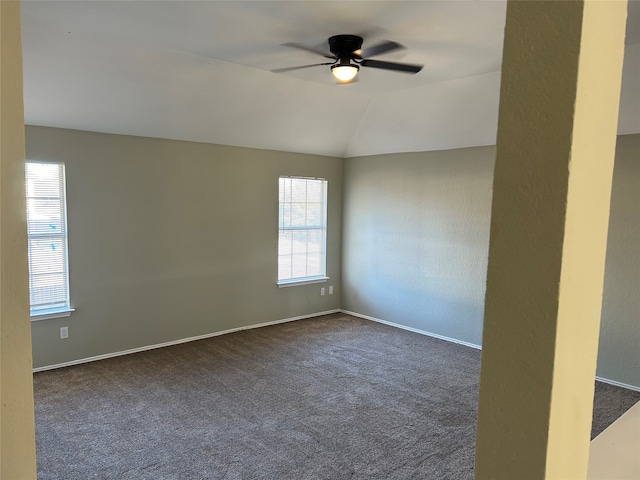 spare room featuring ceiling fan, vaulted ceiling, and dark carpet