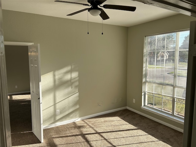 unfurnished room featuring ceiling fan and dark colored carpet