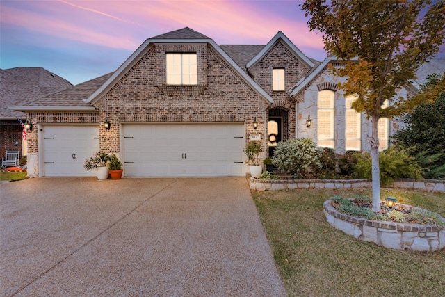 view of front of house with a yard and a garage