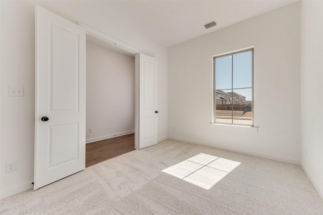 unfurnished bedroom with carpet, visible vents, and baseboards