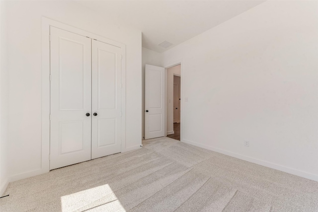 unfurnished bedroom with carpet floors, baseboards, and a closet