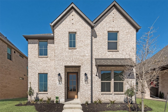 view of front of home with brick siding and a front yard