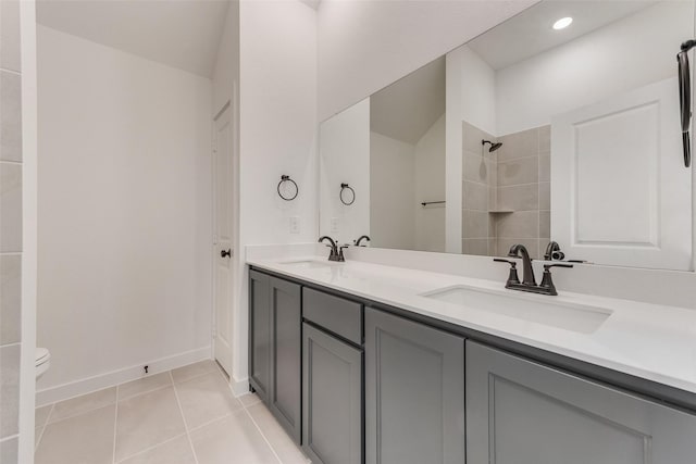 bathroom with double vanity, walk in shower, tile patterned flooring, and a sink