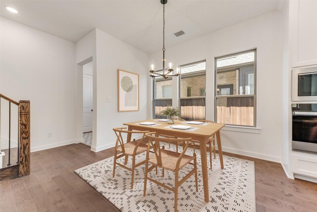 dining area with a wealth of natural light, visible vents, and wood finished floors