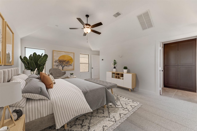 bedroom featuring lofted ceiling, visible vents, ceiling fan, and light carpet