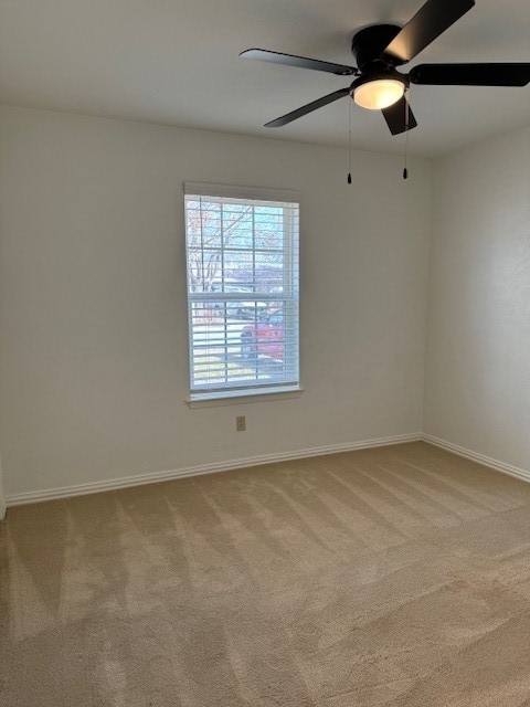 carpeted spare room featuring ceiling fan