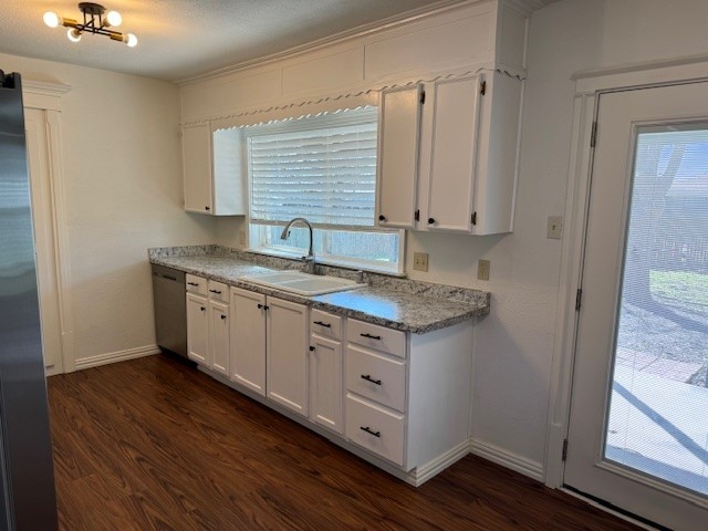 kitchen with dark wood-type flooring, white cabinetry, stainless steel appliances, and a healthy amount of sunlight