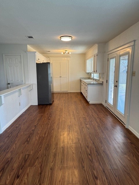 kitchen with french doors, dark hardwood / wood-style floors, sink, stainless steel fridge, and white cabinets