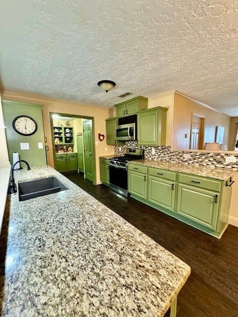 kitchen featuring sink, backsplash, green cabinets, stainless steel appliances, and dark hardwood / wood-style floors