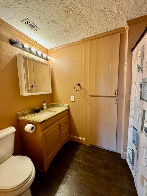 bathroom featuring hardwood / wood-style floors, a textured ceiling, toilet, vanity, and crown molding