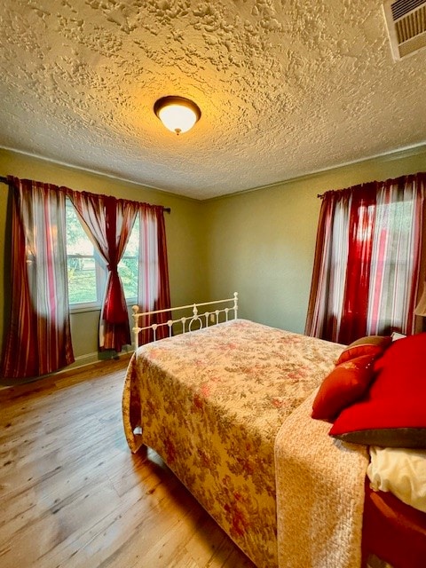 bedroom with hardwood / wood-style flooring and a textured ceiling