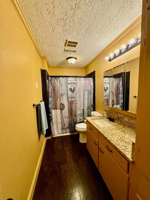 bathroom with vanity, toilet, crown molding, and hardwood / wood-style floors